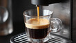 © Алексей Иванченко - The coffee machine pours espresso into a transparent glass cup. Dark liquid with foam on the surface, metal appliance.