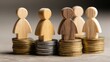 © mila103 - Small wooden figures are positioned on stacks of coins symbolizing the relationship between people and financial resources.