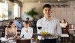 © JackF - Young male waiter posing with tray of salad and wine in restaurant