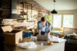© Davor - Young man using laptop amid moving boxes in modern kitchen