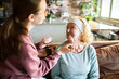 © Geber86 - Caregiver applying face cream to senior woman at home