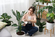 © New Africa - Woman wiping beautiful houseplant leaf at home