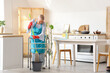 © Pixel-Shot - Mature woman with walker mopping floor in kitchen