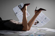 © Pixel-Shot - Legs of woman in high heels with many newspapers on grey background, closeup