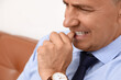 © Pixel-Shot - Worried mature businessman biting nails in office, closeup