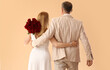 © Pixel-Shot - Happy mature couple with bouquet of roses on beige background, back view. Valentine's Day celebration