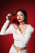 © Pixel-Shot - Beautiful young elegant woman with rose on red background