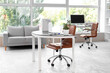© Pixel-Shot - Interior of light open space office with workplace, shelving unit and white sofa