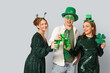 © Pixel-Shot - Happy friends with beer and clover on light background. St. Patrick's Day celebration