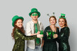 © Pixel-Shot - Group of people with beer on light background. St. Patrick's Day celebration