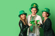 © Pixel-Shot - Happy friends with beer on green background. St. Patrick's Day celebration