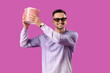 © Pixel-Shot - Happy young man in 3D glasses with popcorn on purple background