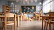 © Bi - Bright, empty classroom with small wooden tables and chairs, toys scattered