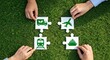 © Adam - Hands assembling puzzle pieces with green transport icons on grass.