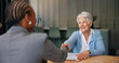 © peopleimages.com - Shaking hands, deal and senior woman with financial advisor in home for discussion on retirement fund. Handshake, documents and elderly female person with investor for finance agreement in house.
