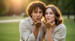 © antuanetto - A cheerful young multiethnic couple blowing kisses to the camera, embodying the romantic love and affection concept in a vibrant golden hour park