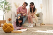 © eggeeggjiew - Warm family moment as Asian parents enjoy watching their daughter drawing on the floor, peaceful indoor activity.