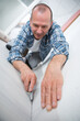 © auremar - male carpet fitter installing carpet with cutter