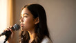 © JunoNaro - young Asian woman singing with microphone