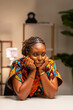 © Roger - Lonely young African woman looking upset, bored, or frustrated, sitting at her home office