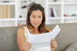 © auremar - serious lady sat on the sofa reading letter