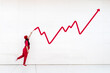 © VISTA by Westend61 - Woman in red drawing upward graph symbolizing business growth