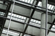 © yaqui_villegas - Industrial architecture structure with steel beams glass ceiling and grid geometry creating abstract interior pattern for modern engineering background