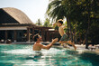 © Jacob Lund - Father and young boy enjoying a playful time in resort pool