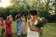 © Jacob Lund - Bride tossing her bouquet surrounded by friends outdoors