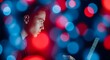 © designhunt - Global communication and high speed fiber optics. Telecommunications and server network. Young man using a laptop surrounded by vibrant blue and red blurred light orbs and bokeh