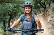 © Lubos Chlubny - Young woman mountain biking giving thumbs up on trail