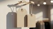 © Farhan Jani - Two blank rustic cardboard price tags hang from a small wooden dowel rod display bathed in warm natural sunlight casting dramatic shadows inside a modern retail boutique setting mock up