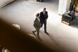 © Westend61 - Bird's eye view of two businessmen walking and talking in a factory
