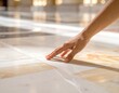 © Demok - Close up Of A Person's Hand Gently Touching A Polished Marble Floor With Sunlight Streaks Across The Surface