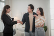 © surachetkhamsuk - Happy Asian family young couple in love hand holding keys when they are buying real estate for new home.