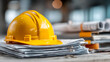 © Prasanth - Yellow hard hat stack construction documents, safety compliance, engineering paperwork, building regulations, site management, contractor audits, permit approvals, occupational safety, risk control