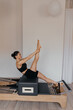 © Anton - Pilates reformer training machine displayed with Pilates sitting box accessory. Two pieces of equipment are visible showing how the box expands reformer functionality and increases exercise variety