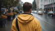 © Thares2020 - Man in yellow raincoat walks on wet city street during rainy weather