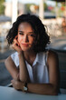 © DaliCeMedia - Beautiful and young curly-haired woman waiting for someone in a cafe, portrait outdoors on a sunny day