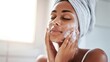 © Anastasiia - A woman with a towel wrapped on her head washes her face with foamy cleanser, eyes closed and smiling. Concept Skincare routine, Spa-at-home, Foamy cleanser moment, Towel-wrapped hair
