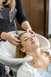© Dulúapics - Client prepared to receive hair wash at salon sink