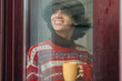 © tetxu - Young man looking out the window on a cold, rainy day while having a hot drink