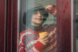 © tetxu - Young man looking out the window on a cold, rainy day while having a hot drink