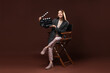 © New Africa - Professional film director with clapperboard on chair against brown background
