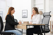 © New Africa - Smiling recruiter and candidate having job interview at table in office