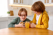 © New Africa - Cute brothers with orange juice at wooden table in kitchen