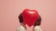 © Vasiliy - A couple joyfully kisses while holding a large heart-shaped balloon, surrounded by floating hearts. This moment captures their deep affection and celebration of love on a special day