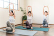 © buritora - Women doing yoga and pilates in a yoga studio or yoga class (sports gym)