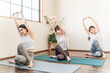 © buritora - Women doing yoga and pilates in a yoga studio or yoga class (sports gym)