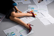 © Pixel-Shot - Young woman in high heels with many newspapers lying on grey background, closeup